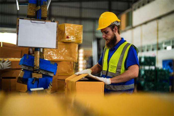 Warehouse staff opening a supplier package and taking product photos for WhatsApp confirmation