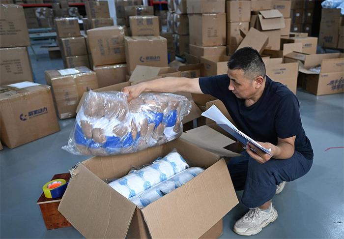 Warehouse staff scanning domestic tracking labels on packages from Chinese suppliers