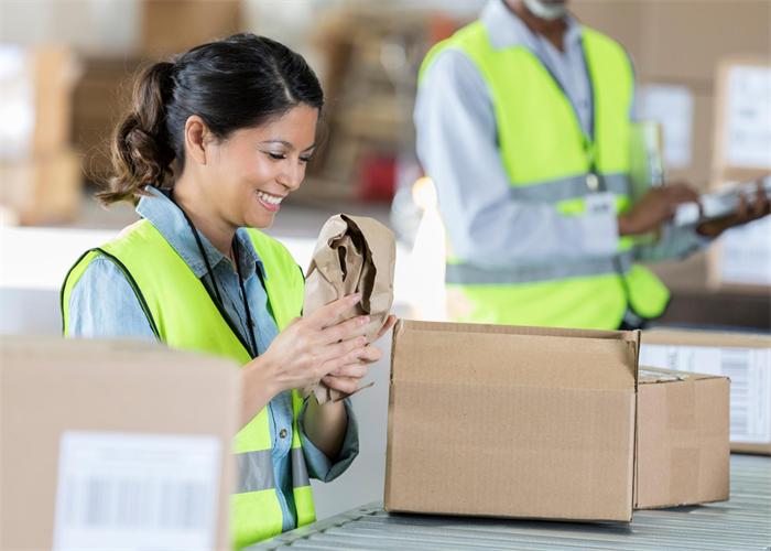 Warehouse worker checking the visible condition of an incoming supplier package